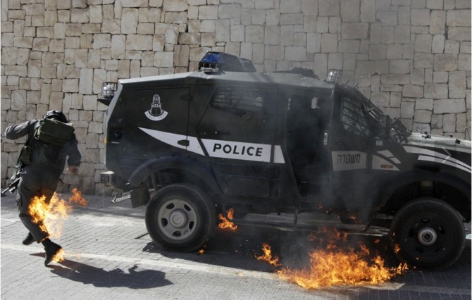 An Israeli border police officer tries to escape from flames after a petrol bomb was thrown at him during clashes with Palestinians Silwan in East Jerusalem March 18 11