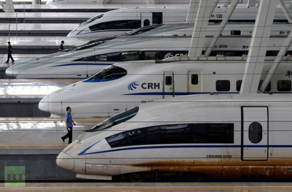 Train employee walks past a CRH Harmony 380BL bullet train at Beijing South Railway Station