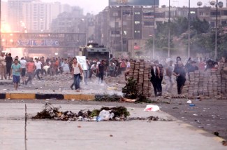 Opponents of deposed Egyptian President Mohamed Mursi throw stones at his supporters during clashes in Nasr city area