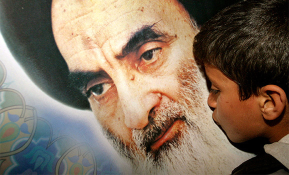 IRAQI SHI'ITE BOY KISSES POSTER OF AYATOLLAH ALI AL-SISTANI IN KARBALA.