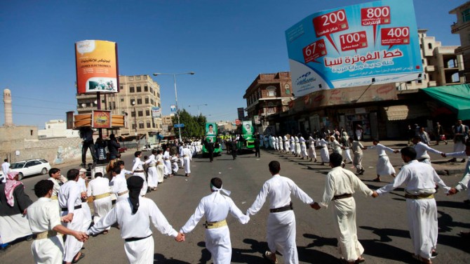 Supporters of the Shiite rebel al-Houthi group, also known as Ansarullah, march as they carry the coffins of two fellow Shiites on cars during an anti-government protest in Sanaa