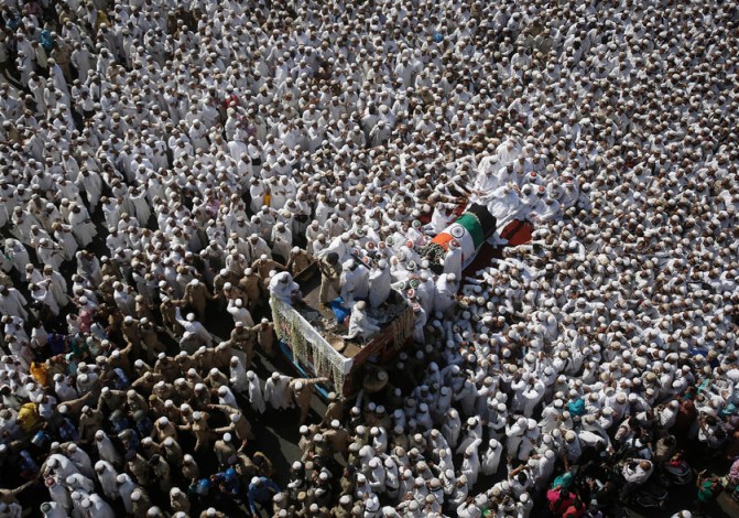 Dawoodi Bohra Muslims crowd around the vehicle carrying the body of their spiritual leader Syedna Mohamed Burhanuddin during his funeral procession in Mumbai