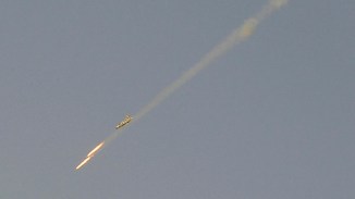 A Syrian Air Force fighter plane fires a rocket during an air strike loyal to Syria's President Bashar al-Assad in Raqqa province, eastern Syria