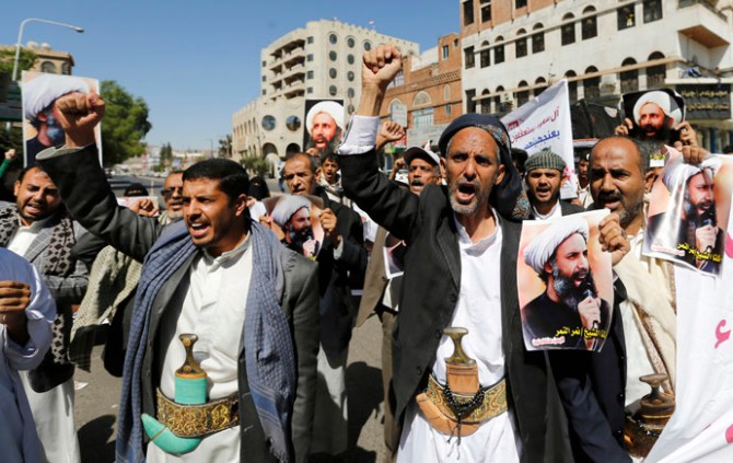 Shi'ite protesters shout slogans as they hold posters of Sheikh Nimr al-Nimr during a demonstration outside the Saudi embassy in Sanaa