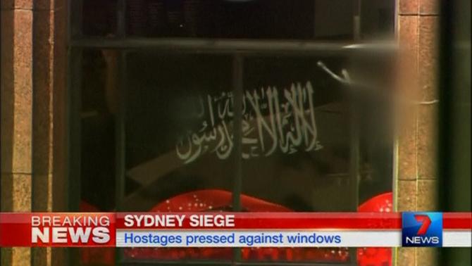 Video grab shows a black flag with white Arabic writing held up at the window of the Lindt cafe, where hostages are being held