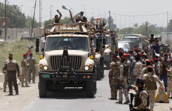 Volunteers, who have joined the Iraqi Army to fight against the predominantly Sunni militants who have taken over Mosul and other Northern provinces, travel in army trucks in Baghdad June 14, 2014.  REUTERS/Thaier Al-Sudani