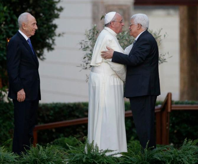 FILE - In this Sunday, June 8, 2014 file photo Pope Francis and Palestinian President Mahmoud Abbas embrace each other as Israel's President Shimon Peres, left, looks at them during an evening of peace prayers in the Vatican gardens. The Vatican officially recognized the state of Palestine in a new treaty finalized Wednesday, May 13, 2015 immediately sparking Israeli ire and accusations that the move hurt peace prospects. The treaty, which concerns the activities of the Catholic Church in Palestinian territory, makes clear that the Holy See has switched its diplomatic recognition from the Palestine Liberation Organization to the state of Palestine. (AP Photo/Gregorio Borgia, File)