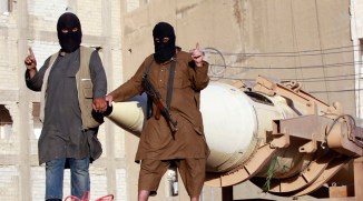 Militant Islamist fighters gesture as they take part in a military parade along the streets of Syria's northern Raqqa province