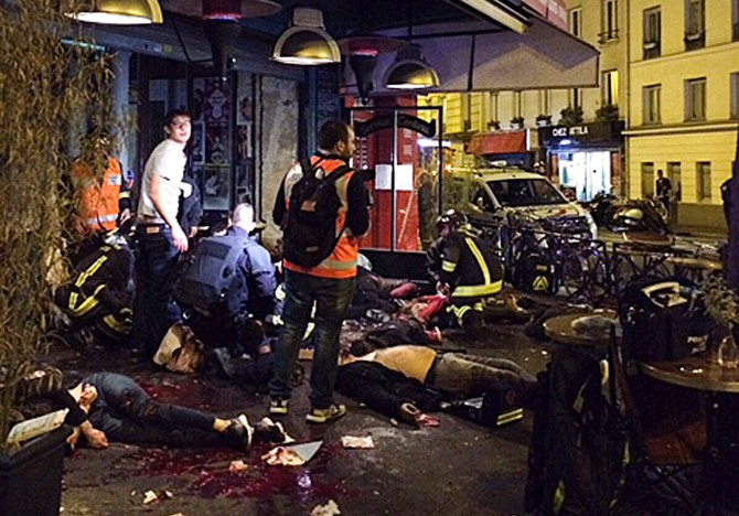 Victims of a shooting attack lay on the pavement outside La Belle Equipe restaurant in Paris Friday, Nov. 13, 2015. Well over 100 people were killed in Paris on Friday night in a series of shooting, explosions. (Anne Sophie Chaisemartin via AP) MANDATORY CREDIT
